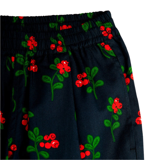 Navy blue pants with red and green floral pattern on a white background