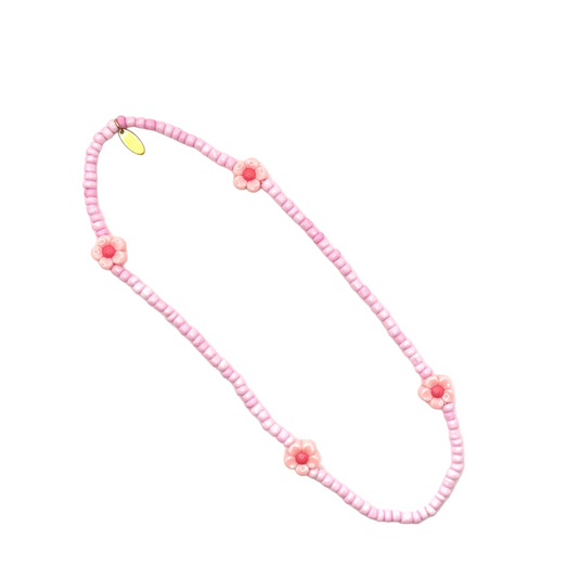 Pink beaded necklace with floral designs on a white background
