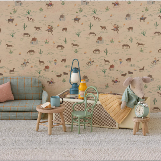 Children's room with patterned wallpaper, sofa, and toys.