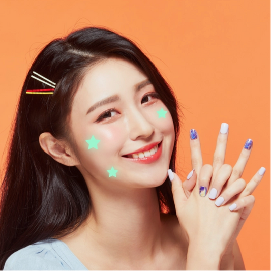 Woman with decorative stars on her face and hands against an orange background