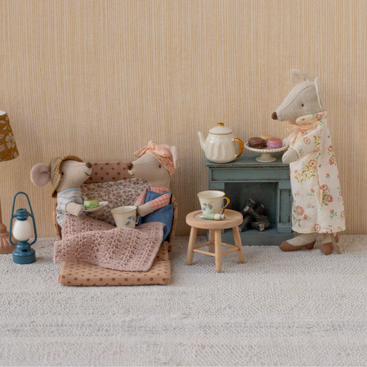 Miniature scene with two toy mice in a cozy room setting.