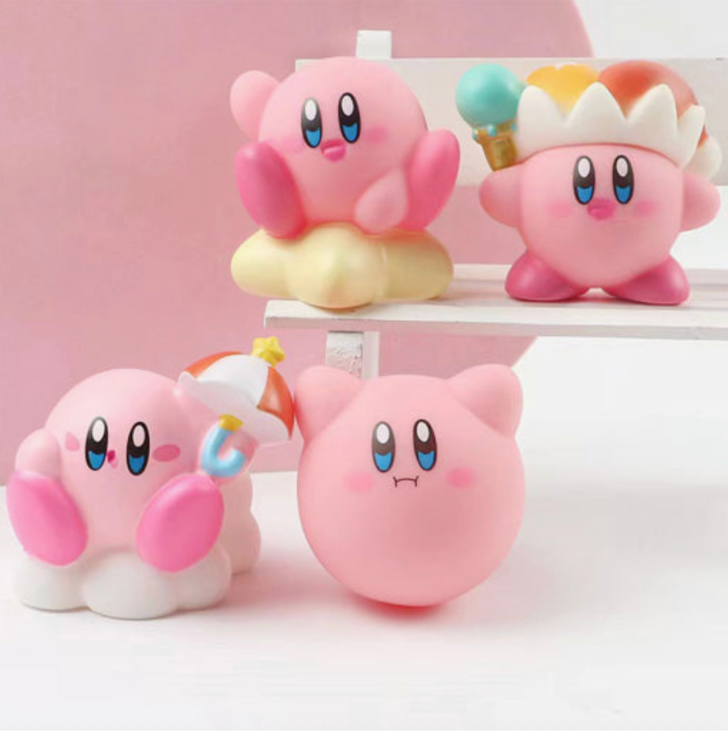 Four pink cartoon characters with blue eyes and colorful hats on a white stand against a pink background.