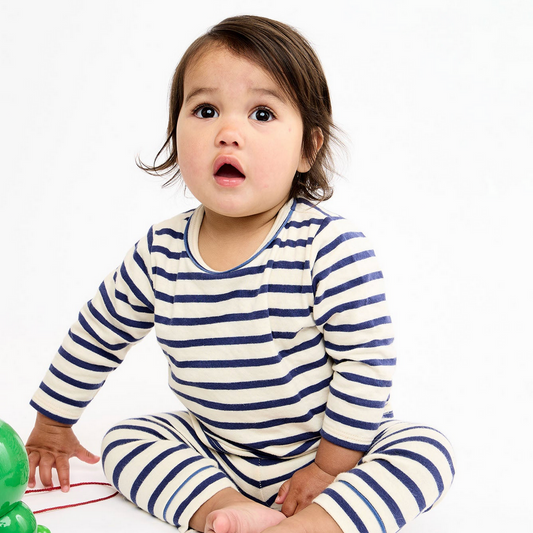 Child wearing a blue and white striped outfit on a white background