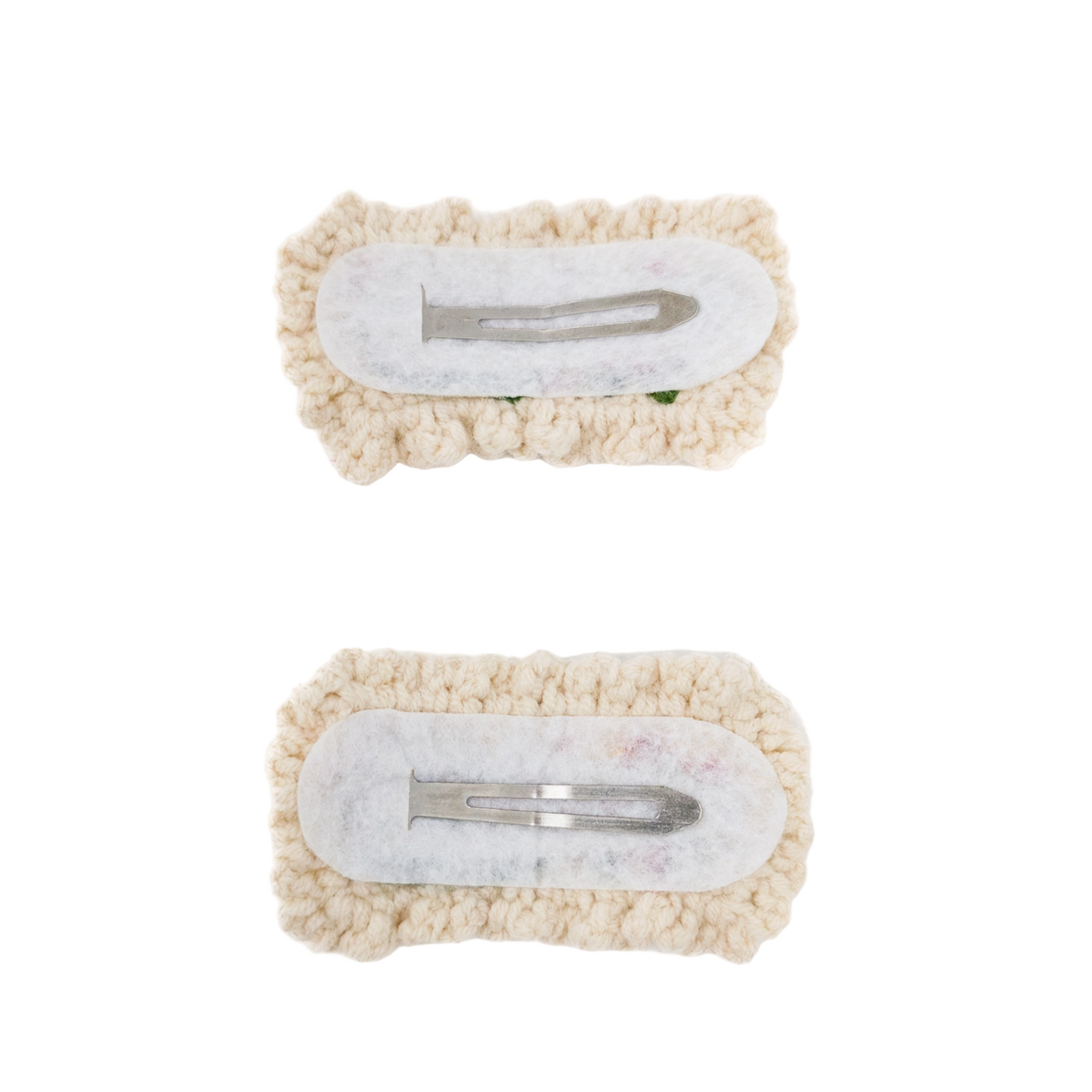 Two decorative hair clips with pom-pom texture on a white background
