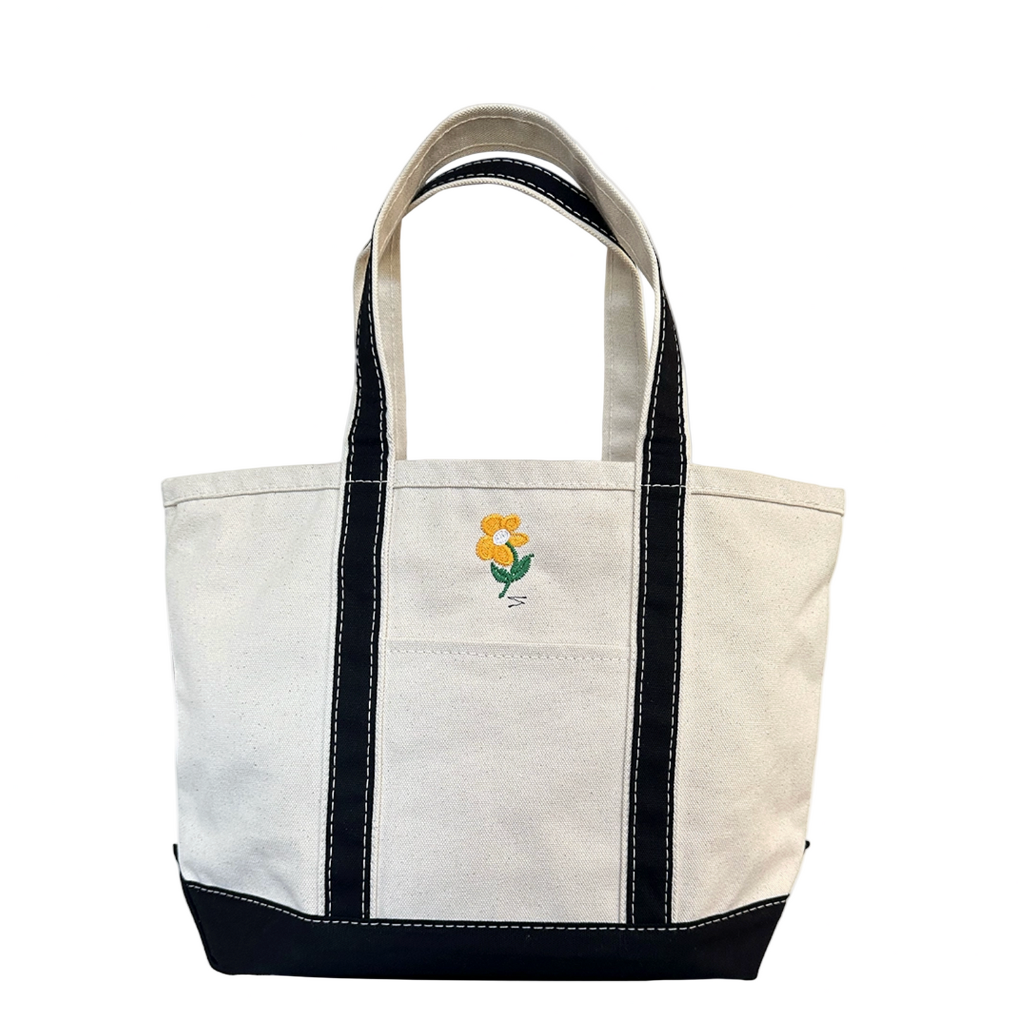 White tote bag with black accents and a small floral emblem on a white background