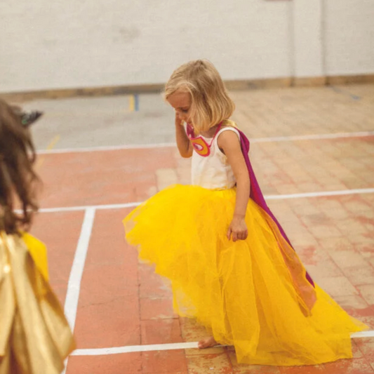 Two children in colorful costumes on a basketball court