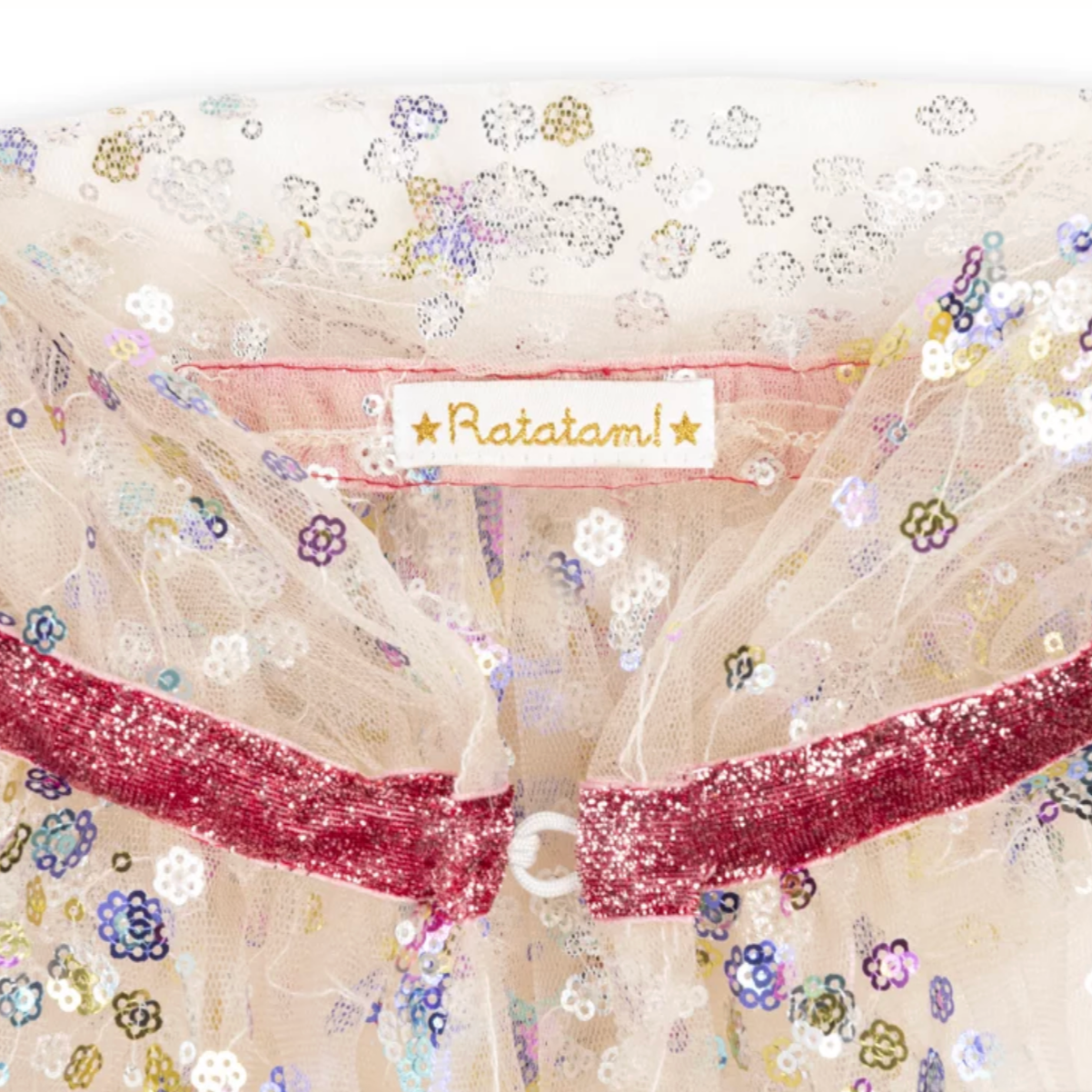 Decorative fabric with floral patterns and a red ribbon, featuring the brand 'Ratatam'.