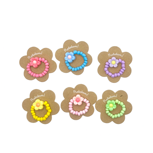 Set of six floral hair ties with colorful beads on a white background