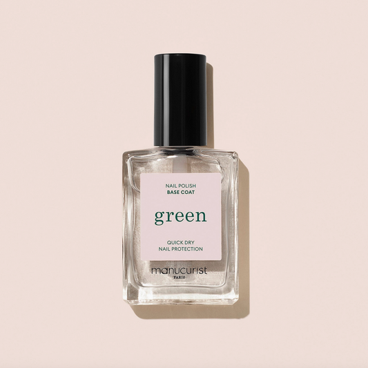 Bottle of nail polish base coat labeled 'green' on a beige background