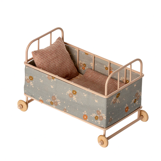 Children's bed with floral pattern and wheels on a white background