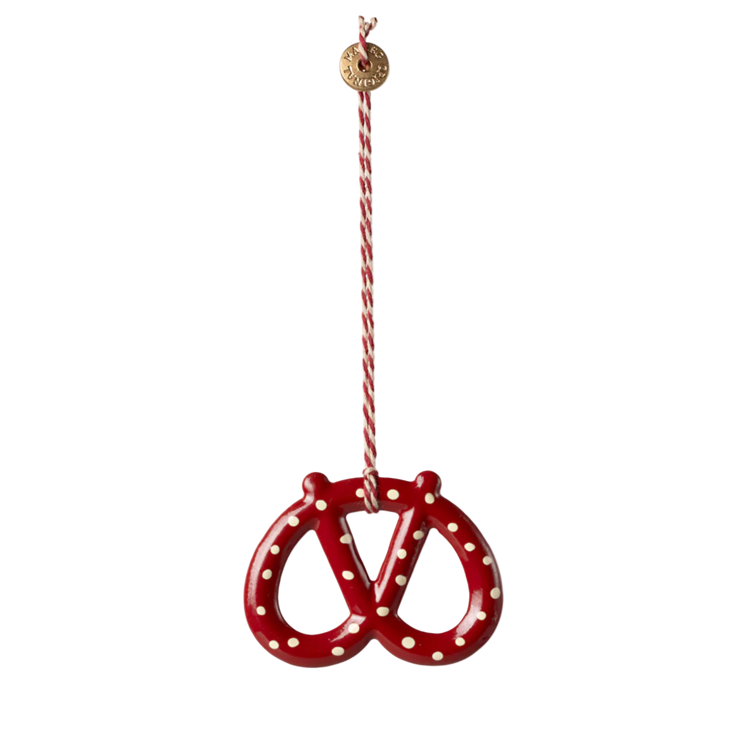 Red pretzel-shaped ornament with white polka dots on a white background