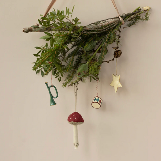 Decorative mistletoe with hanging ornaments on a beige wall