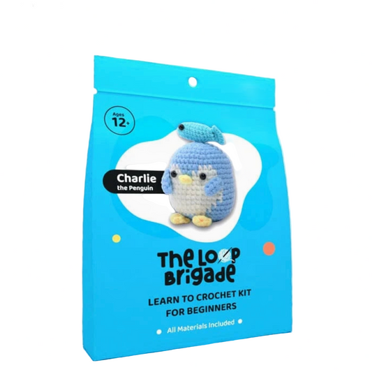 Package of 'The Loop Brigade' learn to crochet kit for beginners with a penguin design on a white background.