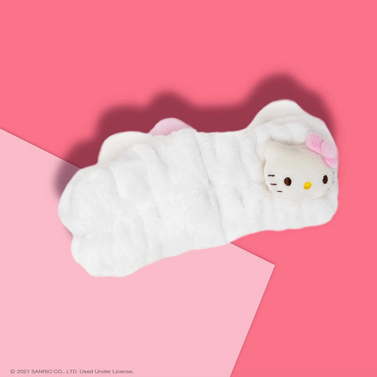 Plush toy resembling a cat character wrapped in white fabric on a pink background