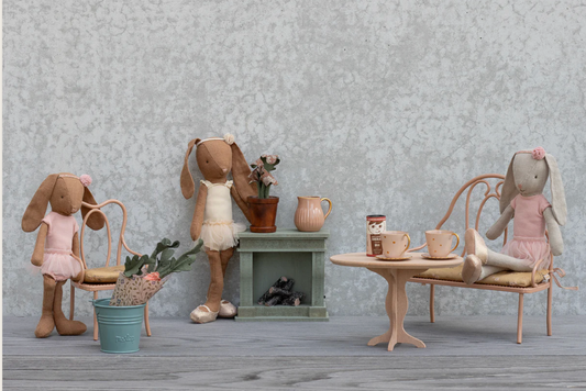 Stuffed animal toys in a room setting with furniture and decor.