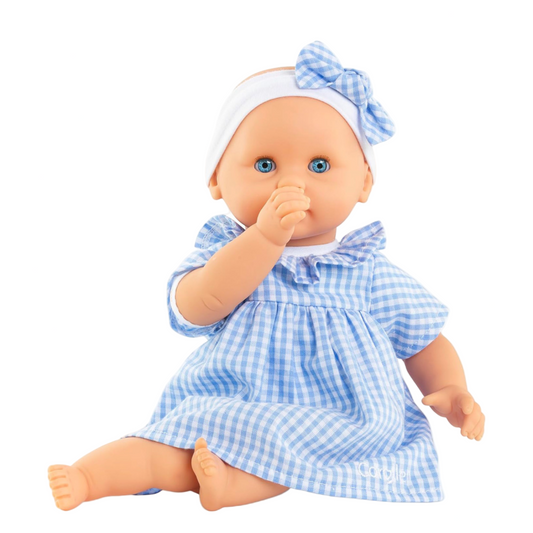 Baby doll in a blue checkered dress and headband on a white background